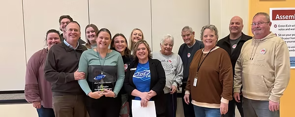 Leslie Geldien receives the Most Valuable Educator Award, surrounded by colleagues and family
